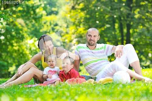 Image of happy young couple with their children have fun at park