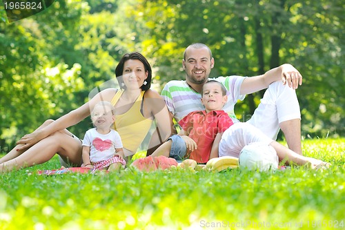 Image of happy young couple with their children have fun at park