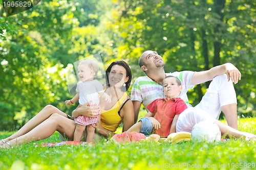 Image of happy young couple with their children have fun at park