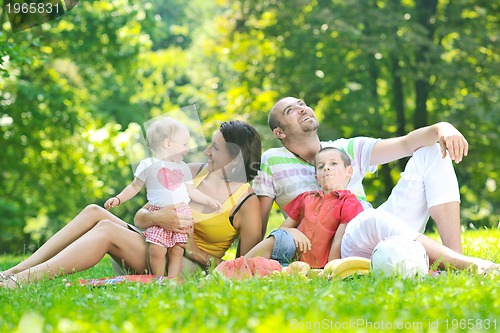 Image of happy young couple with their children have fun at park