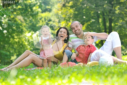 Image of happy young couple with their children have fun at park