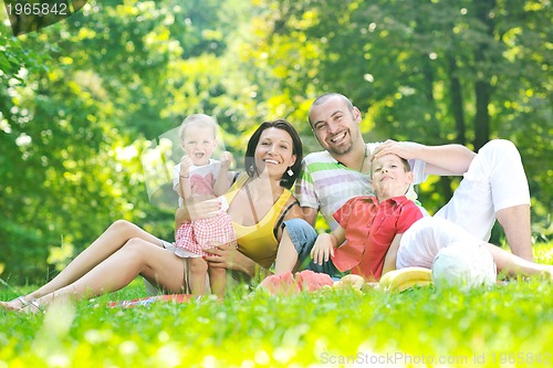 Image of happy young couple with their children have fun at park