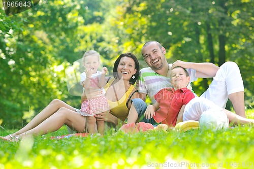 Image of happy young couple with their children have fun at park