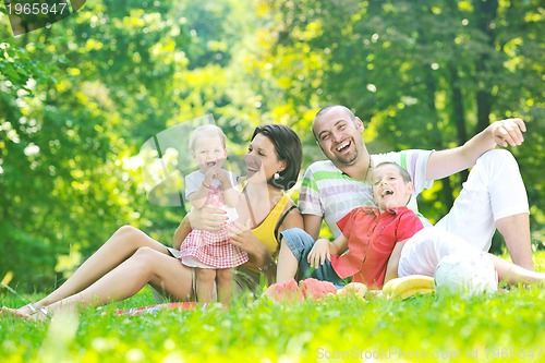 Image of happy young couple with their children have fun at park