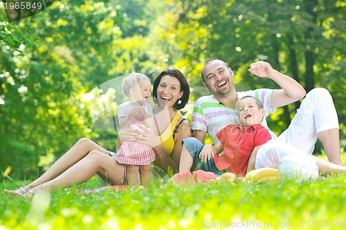 Image of happy young couple with their children have fun at park