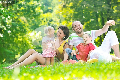 Image of happy young couple with their children have fun at park