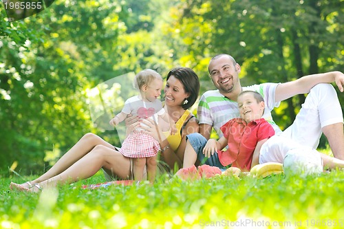 Image of happy young couple with their children have fun at park