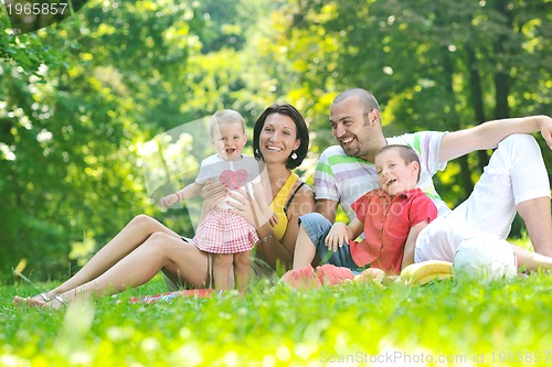 Image of happy young couple with their children have fun at park