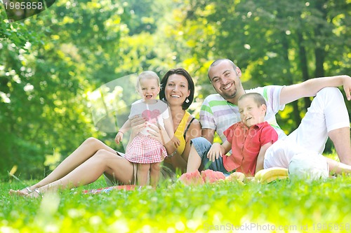 Image of happy young couple with their children have fun at park