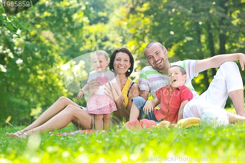 Image of happy young couple with their children have fun at park
