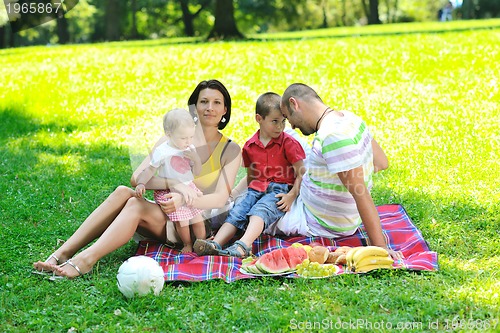 Image of happy young couple with their children have fun at park