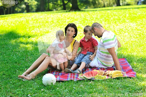 Image of happy young couple with their children have fun at park