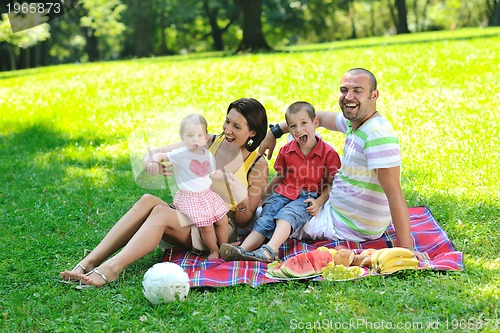 Image of happy young couple with their children have fun at park