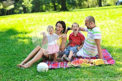 Image of happy young couple with their children have fun at park