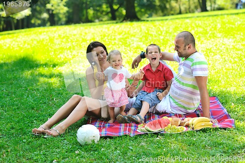 Image of happy young couple with their children have fun at park