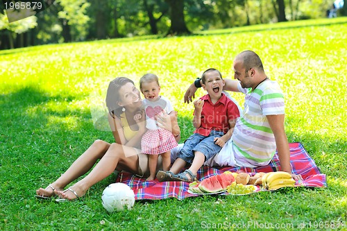 Image of happy young couple with their children have fun at park
