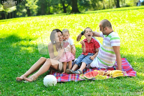 Image of happy young couple with their children have fun at park