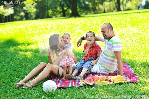 Image of happy young couple with their children have fun at park