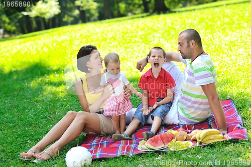 Image of happy young couple with their children have fun at park