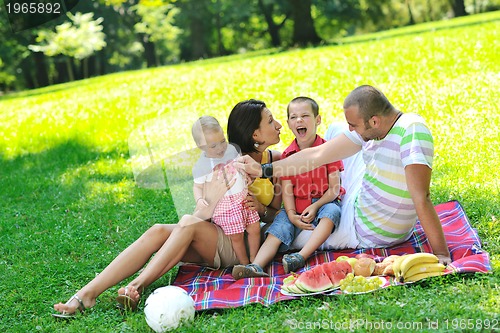 Image of happy young couple with their children have fun at park