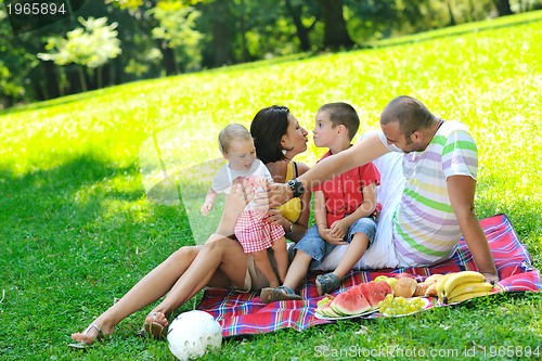 Image of happy young couple with their children have fun at park