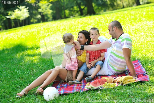 Image of happy young couple with their children have fun at park