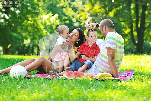 Image of happy young couple with their children have fun at park