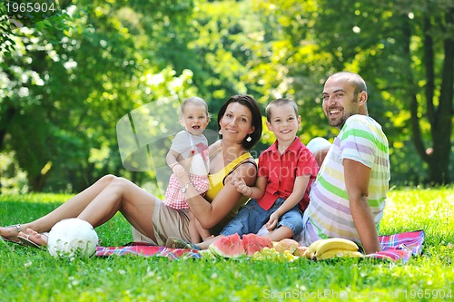 Image of happy young couple with their children have fun at park