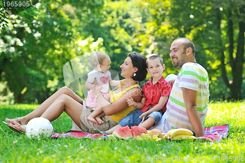 Image of happy young couple with their children have fun at park