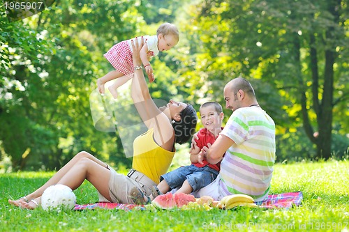 Image of happy young couple with their children have fun at park