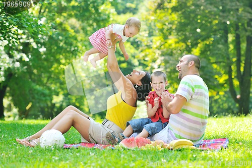 Image of happy young couple with their children have fun at park