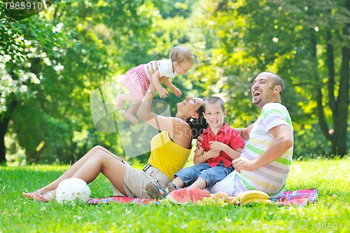 Image of happy young couple with their children have fun at park