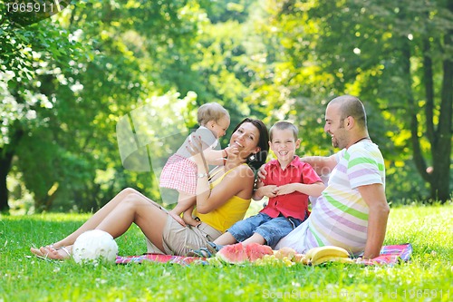 Image of happy young couple with their children have fun at park