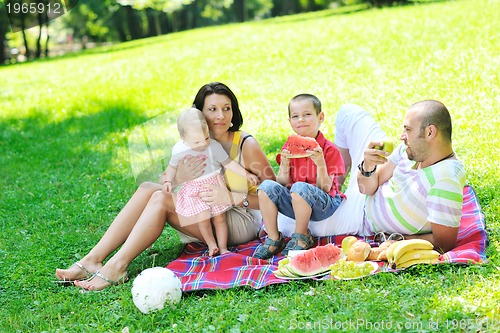 Image of happy young couple with their children have fun at park