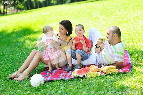 Image of happy young couple with their children have fun at park