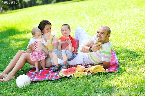 Image of happy young couple with their children have fun at park