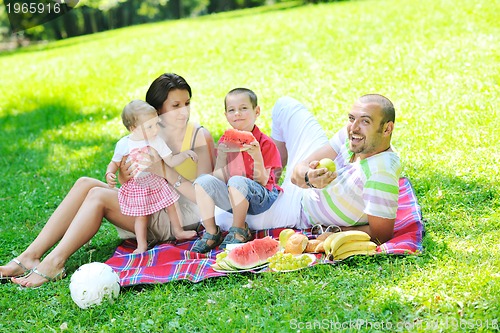 Image of happy young couple with their children have fun at park