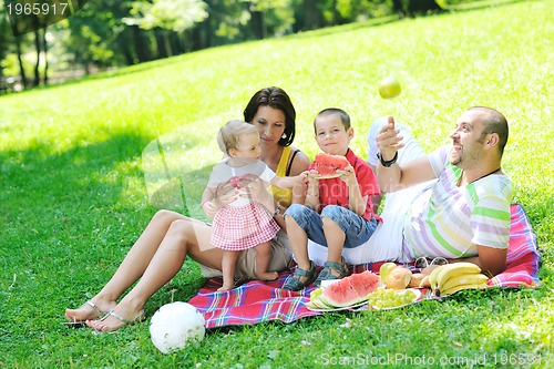 Image of happy young couple with their children have fun at park