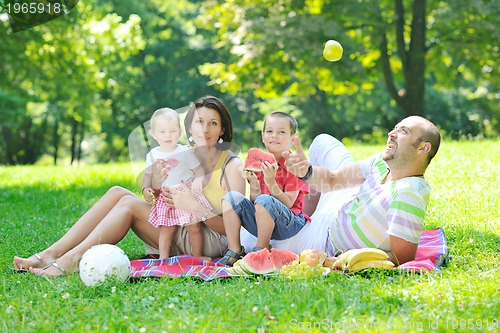 Image of happy young couple with their children have fun at park