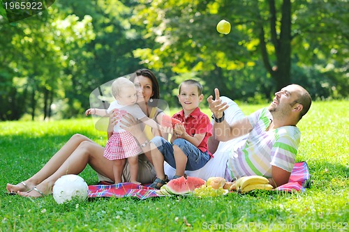 Image of happy young couple with their children have fun at park
