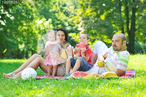 Image of happy young couple with their children have fun at park