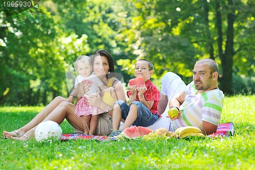 Image of happy young couple with their children have fun at park