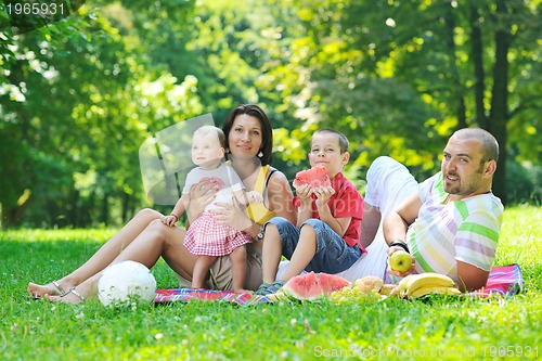 Image of happy young couple with their children have fun at park