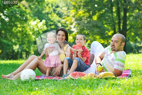 Image of happy young couple with their children have fun at park