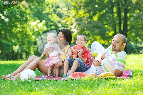 Image of happy young couple with their children have fun at park