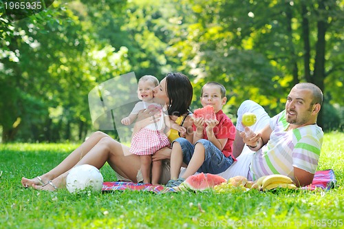 Image of happy young couple with their children have fun at park