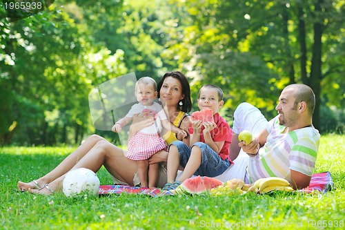 Image of happy young couple with their children have fun at park