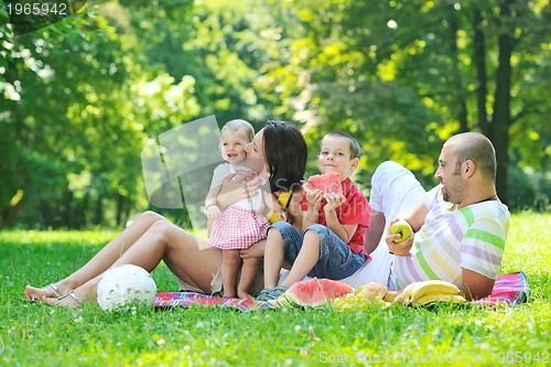 Image of happy young couple with their children have fun at park