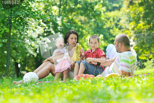 Image of happy young couple with their children have fun at park