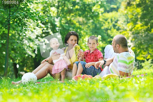 Image of happy young couple with their children have fun at park